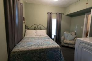 une petite chambre avec un lit et une chaise dans l'établissement Sunshine Cottage 2 bedroom in duplex, à Hastings