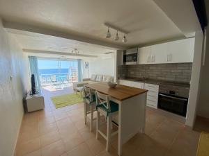 a kitchen with a table and chairs and a view of the ocean at studio with sea view in Salema