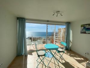 a room with a balcony with a table and chairs at studio with sea view in Salema