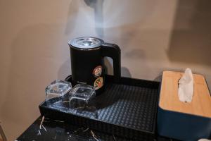 a coffee pot sitting on top of a table at Lorjula INN in Hat Yai
