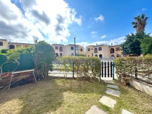 a park with a fence and a bench in a yard at Casa Proserpio in Villasimius