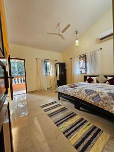 a bedroom with a bed and a ceiling fan at Goan Villa,2BHK, 4Balconies, Beachside,BBQ, Wi-Fi,Work, Group in Candolim