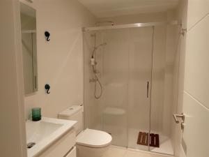 a bathroom with a shower and a toilet and a sink at Hermoso Apartamento cerca de la playa y centro in Tarifa
