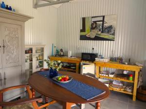 a kitchen with a table with a bowl of fruit on it at Blue Window Shedhouse in Hartebeest Rivier