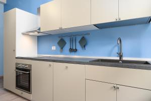 kuchnia z białymi szafkami i zlewem w obiekcie Stylish one - Bedroom Apartment near Città Studi - M4 Argonne Metro Stop w Mediolanie