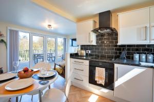 a kitchen with a table and a dining room at Finest Retreats - Lindisview in Caernarfon