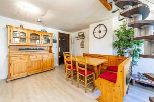 een eetkamer met een tafel, stoelen en een klok bij Lodge & Castle - Beau T3 en Vieille Ville in Annecy