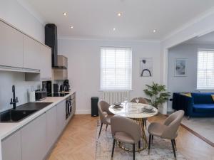 Una cocina y una sala de estar con mesa y sillas. en The Salisbury - 1 Bedroom Deluxe Apartment, en Scarborough