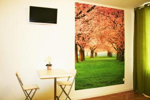 a room with a table and a window with a tree mural at Apartment Lea in Prague