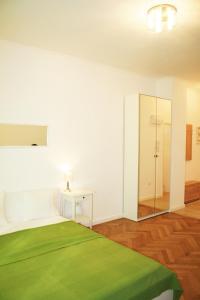 a white room with a bed and a table and a mirror at Apartment Lea in Prague