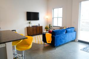 a living room with a blue couch and yellow chairs at The Sunflower Suite in Lawrence