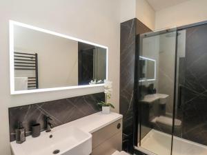Un baño con lavabo blanco y ducha. en The Salisbury - 1 Bedroom Deluxe Apartment, en Scarborough