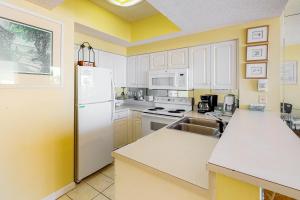 a kitchen with a white refrigerator and a sink at Majestic Sun B0206 in Destin