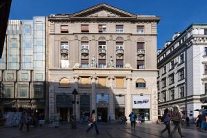 een groot gebouw met mensen die ervoor lopen bij Designer Apartment Eclectica in Belgrado