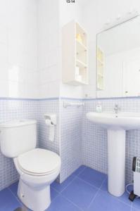 a bathroom with a white toilet and a sink at Apartamentos Bahía Alicante in Alicante +58 photos