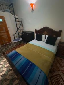 a bedroom with a large bed with a staircase in it at Riad lala Drissia in Gare de Tanger-Fès