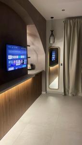 a living room with a tv and a refrigerator at Incanto Luxury Suites 2 in Nafpaktos