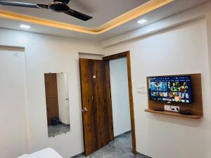 a room with a flat screen tv on a wall at Hotel Mighter Crest in Nashik