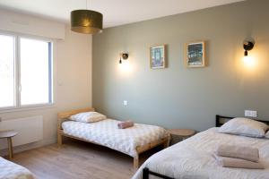 a bedroom with two beds and a window at gite des coulées nantaises in Le Cellier