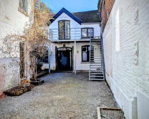 an old house with a staircase leading to a door at La Cachette d 'Amercoeur in Liège