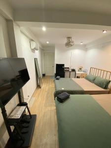 a room with two beds and a flat screen tv at Papaya hotel in Ho Chi Minh City