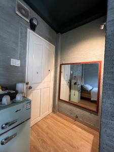 a kitchen with a mirror and a room with a bed at Papaya hotel in Ho Chi Minh City