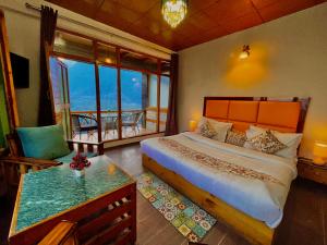 una camera da letto con un letto grande e un balcone di Naina Spring Resort, Manali - away from city hustle a Manāli