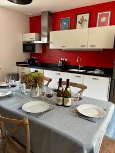 a kitchen with a table with wine bottles and glasses at La Maison des Belles Filles in Pernand-Vergelesses