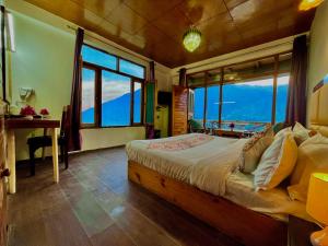 una camera da letto con un letto, una scrivania e finestre di Naina Spring Resort, Manali - away from city hustle a Manāli