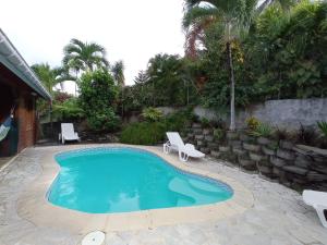 a swimming pool with two lounge chairs in a yard at Alamanda in Sainte-Anne