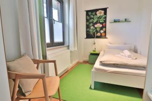 a room with a bed and a chair and a window at Süderdünengarten in Langeoog