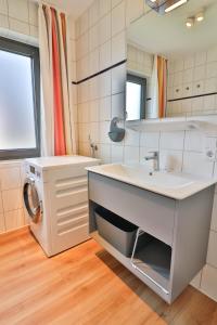 a bathroom with a sink and a washing machine at Süderdünengarten in Langeoog