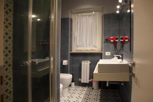 a small bathroom with a sink and a toilet at APPARTAMENTO LAVINIO - Spacious, bright, and thoroughly outfitted with modern amenities - just 150 m from the sea in Anzio +8 photos