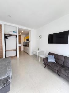 圣玛尔塔Salinas del Mar Torre 4 Apt 903的客厅里有一张沙发，墙上有一台电视