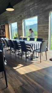 a woman standing at a long table with chairs at Draflastadir Guesthouse in Draflastaðir