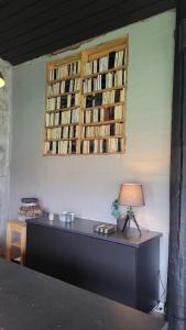 a room with a table with a lamp and books on the wall at Draflastadir Guesthouse in Draflastaðir