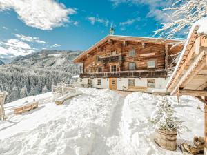 une cabane en rondins dans la neige sur une montagne dans l'établissement Farm Resort Geislerhof, à Gerlos