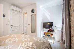 a bedroom with a bed and a desk and a television at Centro di Centri Rooms in Split