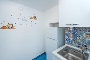 a kitchen with a sink and a refrigerator at Villa Gianna "Nonna Gianna's Home Amalfi Coast" in Conca dei Marini +56 photos