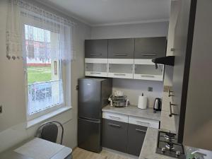 a kitchen with a stainless steel refrigerator and a window at Przystanek Hel in Hel