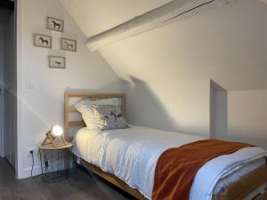 a bedroom with a bed in a white room at Gite Etoile du berger in Ouarville +6 photos