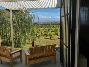 a patio with two benches and a view of a vineyard at KooColand- Container con jacuzzi privado in Tupungato