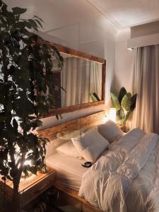 ein Schlafzimmer mit einem Bett mit einem Spiegel und einer Pflanze in der Unterkunft Yari serenity spot in Raʼs Matarma