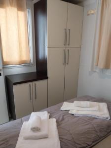 a bedroom with a bed with white towels on it at Villaggio Turistico Maderno in Toscolano Maderno +152 photos