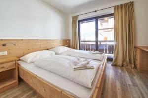 sypialnia z 2 łóżkami i dużym oknem w obiekcie Life & Luxury Appartements w Saalbach Hinterglemm +32 zdjęcia