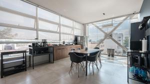 a kitchen with a table and chairs and a large window at Bed in mixed room Hippie Nice in Mexico City