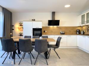 Una cocina con mesa de comedor y sillas. en Am Dahmer Leuchtturm 23d, en Dahme