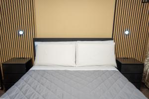 una camera con un letto e 2 comodini. di Meravigghia Syracusae Home a Siracusa