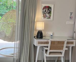 escritorio con lámpara y 2 sillas junto a una ventana en The Green Door Villa Varca Beach with Private pool, en Varca