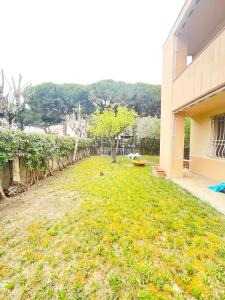 een tuin naast een gebouw met een boom bij Casa Berso' a Marina di Cecina by Zoom In Earth in Marina di Cecina